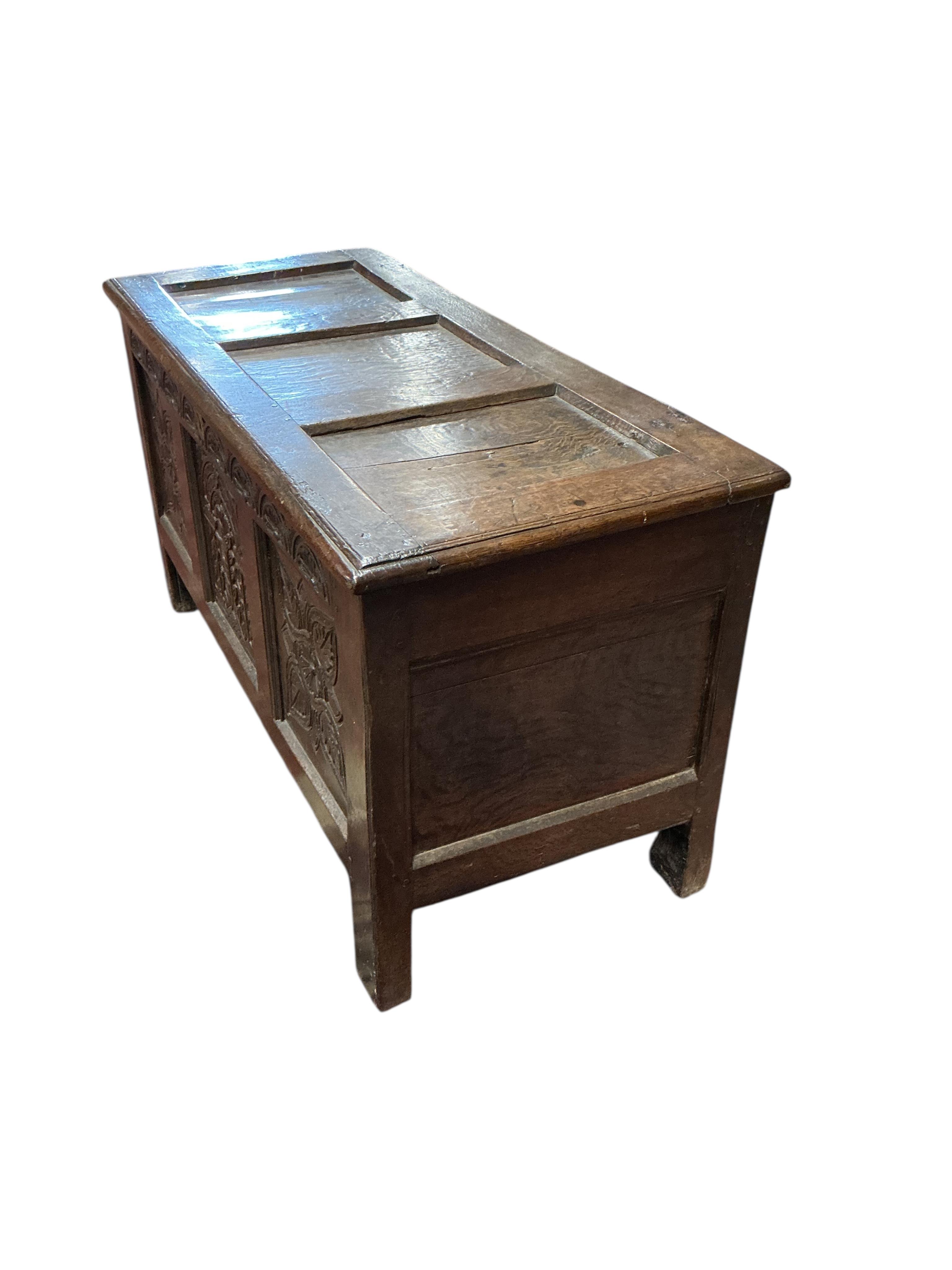 An 18th century carved oak coffer, width 124cm, depth 54cm, height 67cm